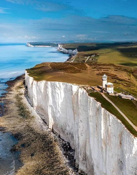 The White Cliffs of Dover is the region of English coastline facing the Strait of Dover and France. The cliff face, which reaches a height of 350 feet, owes its striking appearance to its composition of chalk accented by streaks of black flint, deposited during the Late Cretaceous. The cliffs, on both sides of the town of Dover in Kent, stretch for eight miles. A section of coastline encompassing the cliffs was purchased by the National Trust in 2016. Cliffs Of Dover, White Cliffs Of Dover, Nature Destinations, White Cliffs, East Sussex, Stunning View, Old Pictures, Wyoming, Geology