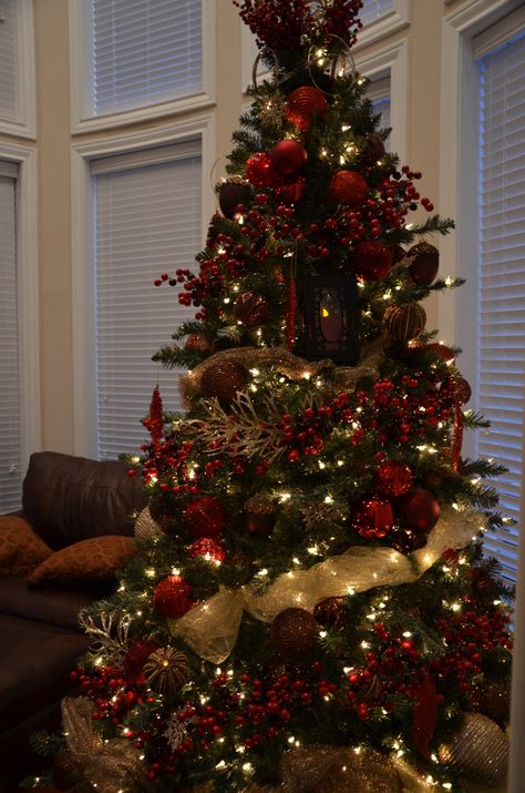 I used different shades of red, a dark brown, and antique gold. I also tied in some large lanterns. Dark Red And Gold Christmas Tree, Red And Gold Ornaments On Tree, Red Gold Brown Christmas Tree, Red And Brown Christmas Decor, Christmas Tree Dark Red, Christmas Tree Red And Brown, Cristhmas Tree, Brown And Red Christmas Decor, Maroon And Gold Christmas Tree