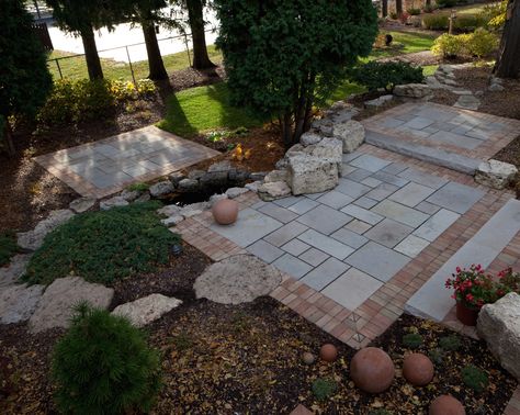 Terraced limestone patio with brick border.  Boulders scribed into the patio provide additional seating and visual interest. Limestone Patio, Front Yard Walkway, Brick Border, Landscaping A Slope, Herb Garden Design, Driveway Landscaping, Outdoor Living Rooms, Patio Stones, Backyard Patio Designs