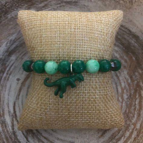 This green bracelet has two shades of green, hematite beads, and a green dinosaur charm. Dinosaur Bracelet, Dinosaur Stuff, Jurassic Park Merchandise, Silly Clothes, Hematite Beads, Christmas Birthday, Jewelry Lookbook, Cool Items, Things To Buy