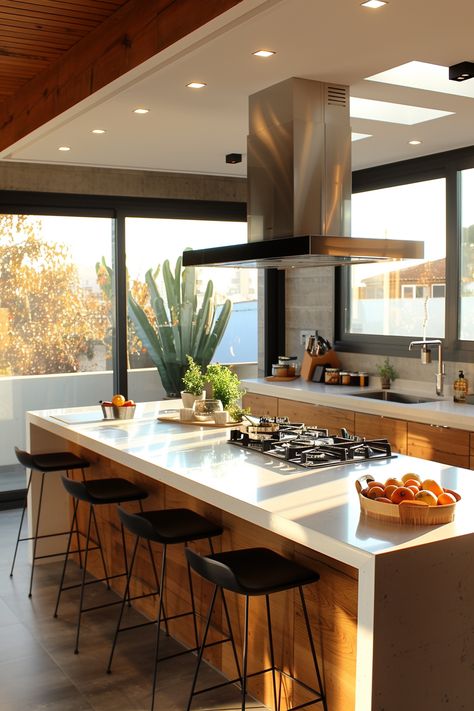 Modern kitchen allure: a spacious island with a gas stovetop, surrounded by refined stools, invites culinary creativity. Bathed in natural light through generous windows, this space harmonizes wooden cabinetry and a sleek metal range hood, while offering a serene cactus vista. Let NOVASPACE PROMOciones bring your dream of sustainable elegance to life. Explore the timeless charm of passive housing today. Kitchen Island Oven Stove, Kitchen Island With Sink And Stove Top, Kitchen Islands With Stove And Oven, Stovetop On Kitchen Island, Kitchen Island With Gas Range, Stove In The Island Kitchen, Range In Kitchen Island, Island Kitchen Stove, Gas Cooktop In Island