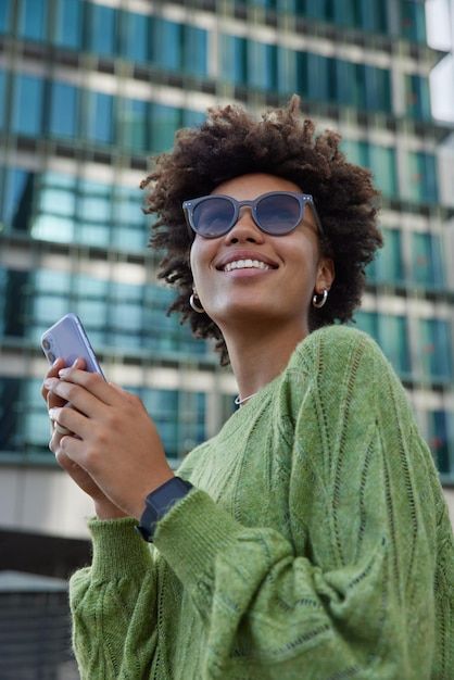 Free Photo | Vertical shot of happy young woman with curly hair holds notepad and pen makes notes what she observes around in city dressed in casual green jumper poses outdoors against blurred background Plain Images, Modern City Building, Mannequin Design, African Portrait, Animal Pictures For Kids, Green Jumper, Hairstyles Design, Church Poster Design, Plaits Hairstyles