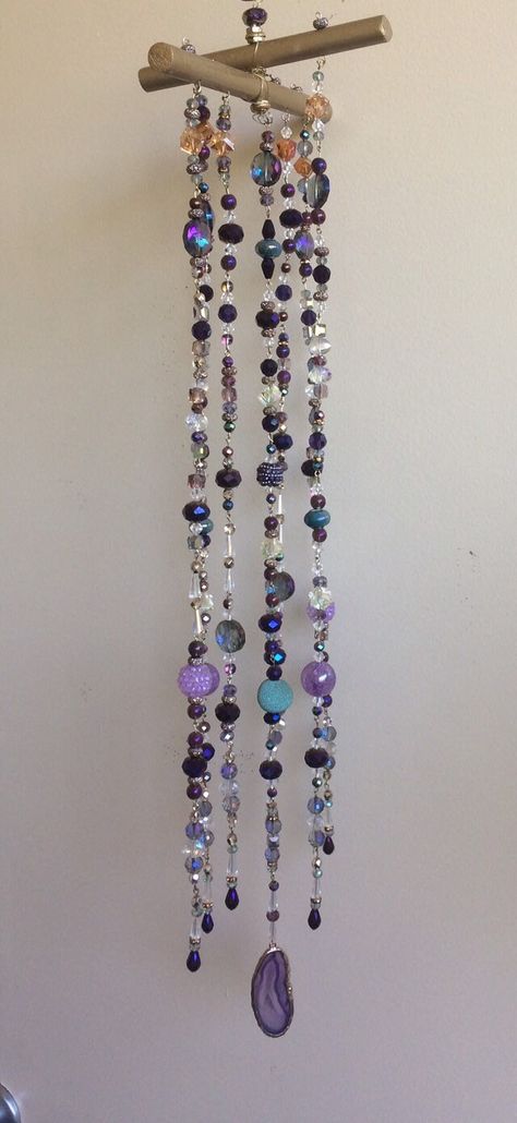 "Purple and teal jewel tones, with gold accents, make this an elegant piece.   Handmade mobile or sun catcher, with 7 strands of glass beads - 5 strands across, with a strand on either side of the center strand.  This piece must hang away from a wall as it won't lay flat like a wall hanging.  Great in a well-lit corner near a window.  The center strand is finished with a slide of agate, and is roughly 23 inches long .  Width is about 7\" by 5.5\"." Hanging Crystals Diy, Crystal Suncatchers Diy, Suncatcher Diy, Handmade Mobile, Wind Chimes Craft, Peacock Colors, Diy Wind Chimes, Purple And Teal, Hanging Beads