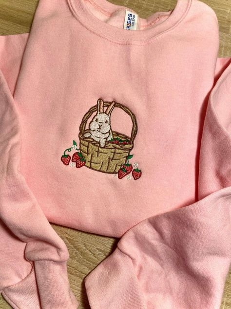 Introducing our Strawberry Basket Bunny Embroidered Sweatshirt 2D Crewneck Sweatshirt, a delightful and charming addition to your wardrobe. Designed for both men and women, this sweatshirt is a perfect blend of comfort, style, and versatility. At first glance, the detailed embroidery of a cute bunny nestled in a basket of fresh strawberries catches your eye. The intricate stitching brings the design to life, adding a touch of playfulness to your outfit. Made with precision and care, this embroid Bunny Clothes Women, Strawberry Embroidered Sweatshirt, Croquette Outfits, Makeup Embroidery, Chloe Outfit, Strawberry Basket, Detailed Embroidery, Diy Embroidery Patterns, Bunny Outfit