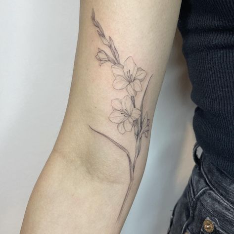 25 Incredible Gladiolus Tattoo Ideas to Inspire You in 2024 Gladiolus Tattoo Shoulder, Gladiolus Hip Tattoo, Gladiolus Rib Tattoo, Gladiolus Tattoo With Name, Gladiolus Tattoo Sleeve, Gladius Flower, Gladiolus Tattoo Simple, August Tattoo Ideas, Gladiolas Tattoo