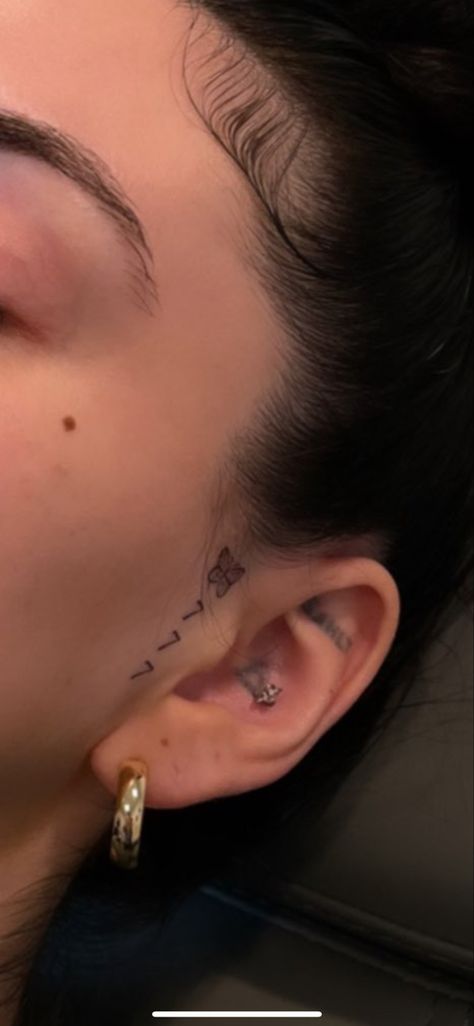 777 Ear Tattoo, Ariana Grande Ear Tattoo, Beauty Mark Tattoo Face, Small Face Tattoos For Women By Ear, Cheek Tattoo For Women, Face Tattoos For Women Eyebrow, Little Face Tattoos, Evil Eye Tattoo Behind Ear, Above Eyebrow Tattoo