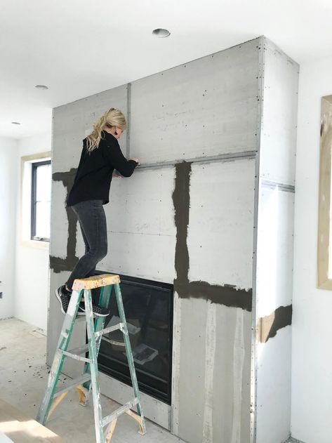 How to DIY a Faux Concrete Fireplace Cement Smear Fireplace, Concrete Skim Coat Fireplace, Cement Fireplace Makeover, Large Cased Openings Between Rooms, Symmetrical Living Room With Fireplace, Plastered Fireplace Ideas, Basement Fireplace Remodel, New Build Fireplace Ideas, Dark Fireplace Ideas