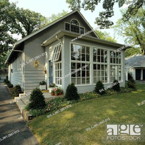 SUNROOMS: Front of small grey stucco bungalow, addition of sunroom, Stock Photo, Picture And Rights Managed Image. Pic. SHL-LJW1-2861-015 | agefotostock Sunroom Front Of House Exterior, Front Of House Sunroom, Front Sunroom Entrance, Sunroom Front Of House, 3 Season Room Addition, Stucco Bungalow, Entryway Exterior, Bungalow Addition, Grey Stucco