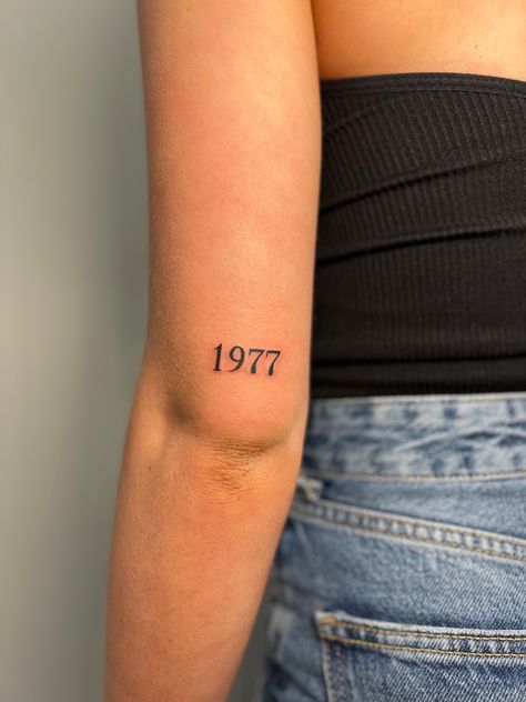 Birth Year Tattoo Above Elbow, Year Born Tattoo Ideas, Year Tattoo On Wrist, 1967 Tattoo Date, Born Year Tattoo Ideas, Birth Year Tattoo Elbow, Dates On Back Of Arm Tattoo, Parents Year Of Birth Tattoo, Angel Number Tattoo Back Of Arm