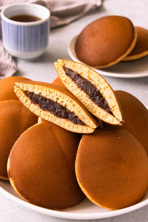 Learn how to make traditional Japanese Dorayaki (red bean pancakes. Make soft and fluffy honey pancakes with a sweet red bean filling. Japanese red bean pancake is very easy to make and involves a simple pancake batter. Japanese pancakes are small and round, typically no larger than the average doughnut. Like regular pancakes, dorayaki is made with common pancake ingredients but honey and mirin gives dorayaki its earthy, marshmallowy flavour and moistness. #dorayaki |www.foodelicacy.com Dorayaki Pancake, How To Make Dorayaki, Soft Pancakes, Red Bean, Dorayaki Recipe, Easy Pancake Batter, Honey Pancakes, Japanese Cookies, Japanese Food Traditional