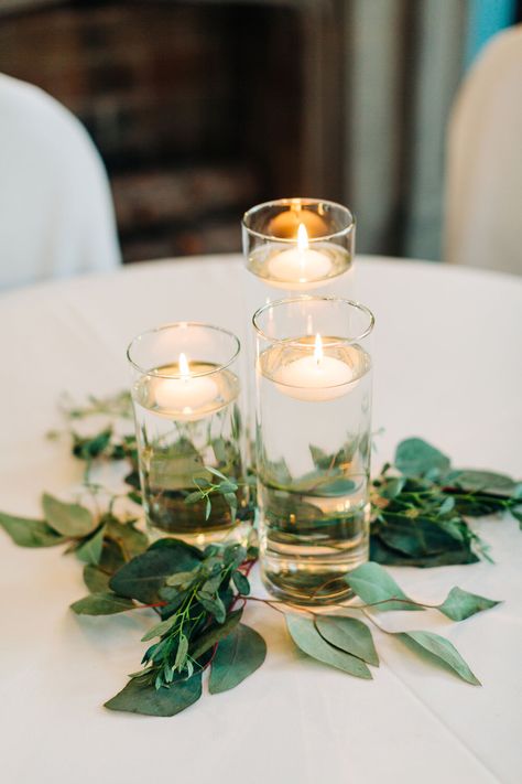 Floating candles with greenery wedding reception Floating Candles For Wedding, Floating Candle Centerpieces Eucalyptus, Floating Tea Candle Centerpieces, Simple Cheap Centerpieces Wedding, Inexpensive Reception Centerpieces, 3 Floating Candle Centerpieces Wedding, Candle Round Table Centerpiece, Floating Tea Lights Wedding, Tea Candle Wedding Centerpieces