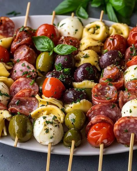 Delicious Italian Antipasto Skewers with marinated tortellini, mozzarella, salami, olives, and fresh basil. Perfect for parties! Marinated Tortellini Skewers, Italian Antipasto Skewers, Marinated Mozzarella Balls Appetizers, Marinated Olives Appetizer, Olives Appetizer Ideas, Make Ahead Italian Appetizers, Caprese Skewers With Salami, Italian Charcuterie Board Appetizers, Tortellini Kabobs Antipasto Skewers