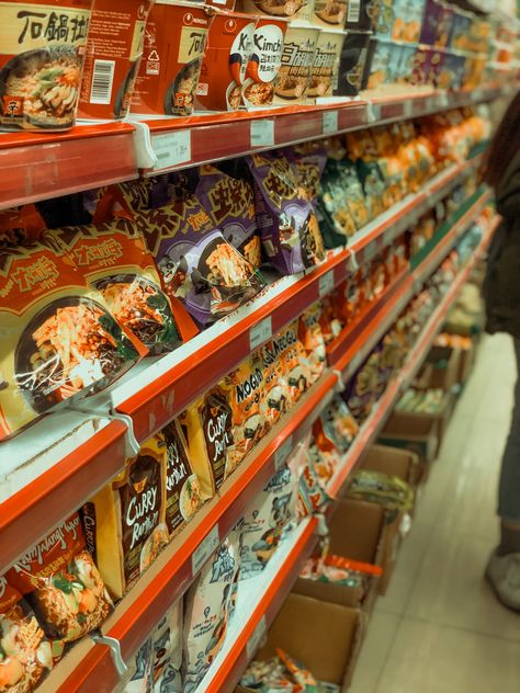 Rows of colorful noodle packets line the shelves in the bustling Asian grocery store. A vibrant display of culinary possibilities, these packaged noodles promise a delicious journey into Asian cuisine. Asian Grocery Store, Asian Noodles, Asian Grocery, Instant Noodles, Grocery Store, Noodles, Shelves, Quick Saves