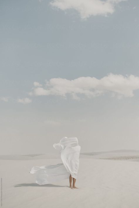 White on white conceptual full body portrait of a flowy piece of material draped over a hiding human body silhouette standing alone in the middle of an open empty desert landscape with a bright blue and cloudy sky Human Standing, Blowing In The Wind, Dream Symbols, Never The Same, Peace Be Upon Him, 인물 사진, Photography Inspo, Blue Aesthetic, Creative Photography