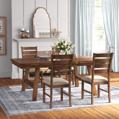 This dining table set creates a gathering space with plenty of room and a modern look. It includes one expandable table with a leaf and six dining chairs, all in a natural smoky walnut tone. The dining table is crafted from engineered wood with flared legs and crossbar supports. Each chair is crafted from solid wood with ladder backs and seats upholstered in a contrasting light polyester fabric. We love that this dining table has space for up to eight people when fully expanded, so it's great fo Light Table Dark Chairs, Modern Antique Dining Room, Dining Room Table With Bench And Chairs, Cabin Kitchen Table, 4 Person Dining Table, Light Brown Dining Table, Dinner Table Set, Dinner Chairs, Farmhouse Dining Table Set