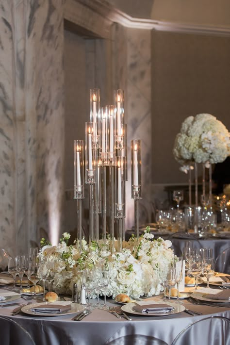 Modern crystal candelabra with white flowers around the base. Modern white wedding floral design. PC: Femina Photo + Design https://feminaphoto.com/ Candelabra And Flower Centerpieces, Wedding Candelabra Flowers, Flower Stand Centerpiece Wedding, Modern Candelabra Centerpiece, Champagne Wedding Florals, Wedding Candelabra Centerpiece, Modern Wedding Reception Decor, Candle And Flower Centerpieces Wedding, Candles Aesthetic Wedding