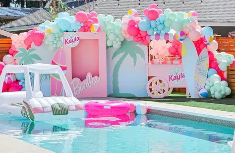 Pool with big malibu Barbie backdrop. Colorful balloons Malibu Barbie Birthday Party Food, Barbie Pool Party Ideas Decoration, Hawaiian Barbie Party, Malibu Barbie Pool Party Ideas, Malibu Pool Party, Malibu Beach Barbie Party, Malibu Barbie Theme, Barbie Swim Party, Barbie Float