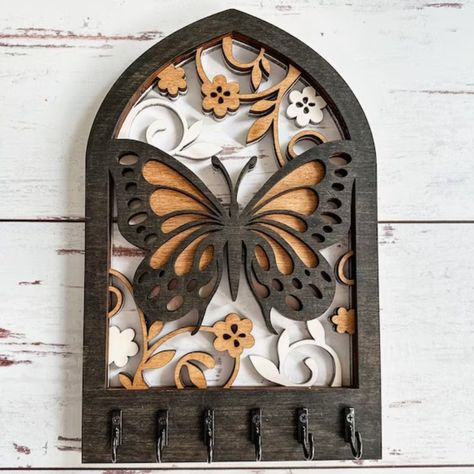 This butterfly wall key holder is a unique and functional home accent that will add a touch of whimsy to any space. Made from solid wood and hand-painted in a vibrant rainbow of colors, this key holder is sure to turn heads. It's also a great way to keep your keys organized and within.#laserkeyholder #keyorganization #customkeyholder #keyaccessories #keyholderdesign Key Holder Wall, Wooden Key Holder, Laser Cut Wood Crafts, Butterfly Motif, Laser Art, Functional Home, Wall Key Holder, Key Hanger, Delicate Beauty