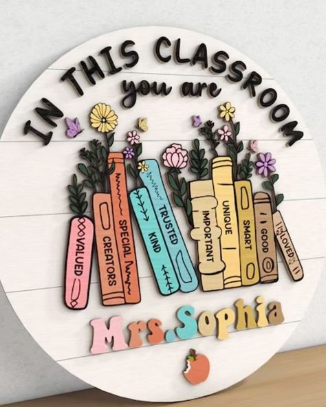 This teacher name sign is perfect with its inspirational 3D words & floral books. 📚 This sign is amazing for the classroom! 🏫 Personalize it here! 🔗 https://kaitlynroseco.com/products/teacher-name-sign-inspirational-floral-books . . #teachersign #teacherdoorsign #teacherdoorhangers #teacherlife #teachergifts #3ddoorsign #lasercut #lasercutting #laserengraving #laserengraved #shopsmall #shoplocal #shophandmade #mamaownedbusiness Class Names Display, Classroom Door Signs Teacher Name Diy, Classroom Signs Wooden, Cute Door Decorations Classroom, Diy Teacher Sign, Teacher Name Signs Diy, Aesthetic Classroom Decor, Teachers Day Decoration, Classroom Door Sign