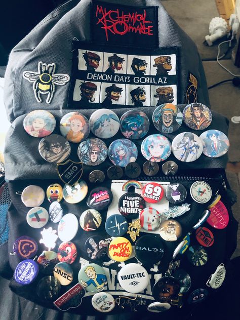 Grey bag covered in badges and pins from varying shows and music artists Badges On Backpacks, Pins On Bag, Scene Backpack, Bag Pins Aesthetic, Backpack With Pins, Punk Fashion Diy, Backpack Art, School Bag Essentials, Aesthetic Backpack