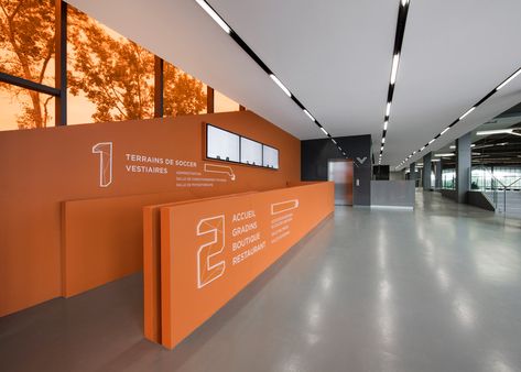 Crystalline soccer stadium by Saucier + Perrotte and HCMA Entrance Lobby Design, Wall Typography, Soccer Center, Sports Office, Lobby Interior Design, Wall Signage, Entrance Lobby, Soccer Stadium, Lobby Interior