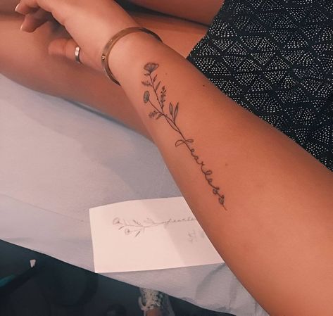 27 Stunning Forearm Tattoos To Vamp Up Your Femininity Words In Tattoos, Floral Forearm Tattoo Simple, Forearm Word Tattoos For Women, Down The Forearm Tattoo, Tattoo On Back Of Arm Women, Tattoos On The Forearm For Women, Girl Tattoos On Arm Ideas, First Tattoo Ideas Forearm, Tattoos Down The Side Of Ribs