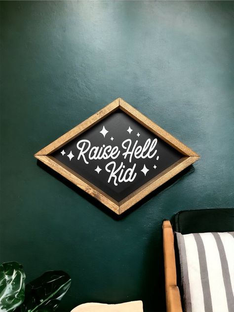 "The sign pictured is 18\" wide and 11\" tall. All signs come with hanging hardware. Raise hell kid - wood sign - diamond shape frame - boho nursery - boho kids room - wall art - home decor -" Punk Nursery, Western Baby Nurseries, Edgy Baby, Dark Nursery, Country Nursery, Western Nursery, Boho Kids Room, Boy Nursery Themes, Nursery Boho