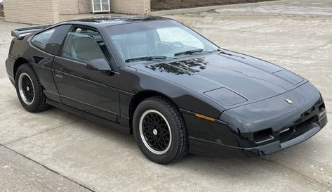 This garage-kept 1988 Pontiac Fiero GT is one of the approximately 26,000 Fieros produced during its final model year and is reportedly the last one made with a manual transmission. It features a two-seater cabin ahead of a mid-mounted 2.8-liter V6 that sends its power to the road through a 5-speed manual gearbox and the rear wheels. Auction ends February 9th! Visit AutoHunter.com! Pontiac Fiero Gt, Pontiac Fiero, Grey Doors, Steering Column, Leather Bucket, Rear Wheel Drive, Bucket Seats, Spare Tire, Leather Interior