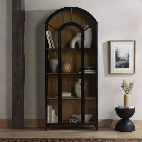 Introducing our 🌟BRAND NEW🌟 Belmont cabinet! Display barware, books and keepsakes in this beautifully arched cabinetry. Solid iron sheeting is finished in a soft, matte black with contrasting brass hardware. Glass fronts allow back paneling of light oak veneer to show, for an eye-catching contrast of color. Overall Dimensions: 39.50”w x 15.75”d x 92.50”h // $2395 ❤️ #displaycabinet #bookcase #bookshelf #storage #cabinet #ironfurniture #officefurniture #modernfurniture #modernfurnituredesign... Black Display Cabinet, Cabinet Glass Doors, Dining Cabinet, Cabinet Glass, Metal Cabinet, Glass Cabinet Doors, Oak Cabinets, Four Hands, Oak Veneer