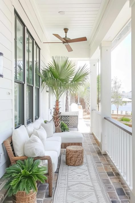 coastal front porch with potted palm tree and woven sofa with white cushions Front Porch Outdoor Furniture, Beach House Back Porch, Coastal Alfresco Outdoor Living, Coastal Patio Decorating Ideas, Coastal Back Porch, Florida Style Homes Exterior, Beach Cottage Porch, Outdoor Patio Mood Board, Coastal Courtyard Ideas