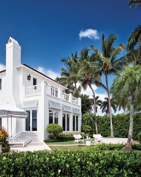 The team splashed the home’s façade in Benjamin Moore’s Vanilla Milkshake and added shutters in Sherwin-Williams’ Niebla Azul. The back exterior’s umbrellas and furnishings are by Janus et Cie, including chaise lounges with Perennials fabric cushions. West Indies House, Coastal Home Exterior, Bahama Shutters, Beach House Tour, Janus Et Cie, Vanilla Milkshake, Architecture Home, Luxurious Home, Shutters Exterior