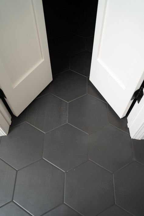 Black Tile Guest Bathroom, Black Hexagon Tile Floor Laundry Room, Black Hexagon Tile Black Grout, Bathroom Dark Hexagon Tile Floor, Black Hexagon Tile Bathroom Floor With Wood Vanity, Black Hexagon Tile Grout Color, Black Hex Floor Tile, Grey Honeycomb Tile Bathroom, Black Octagon Tile Bathroom Floor