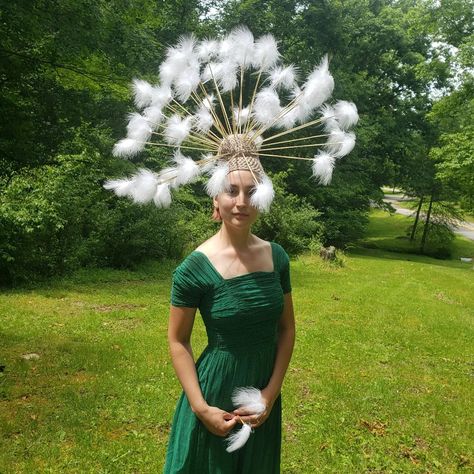 A girl in a green dress standing in the sunshine on a grassy hill. She is wearing a brown crocheted cap that has sticks with feathers at the end stuck in the top creating the illusion of a dandelion that has gone to seed. Dandelion Inspired Fashion, Dandelion Halloween Costume, Dandelion Hat Diy, Dandelion Costume Diy, Dandelion Costume, Dandelion Hat, Dandelion Crown, Carnival Flowers, Dandelion Dress