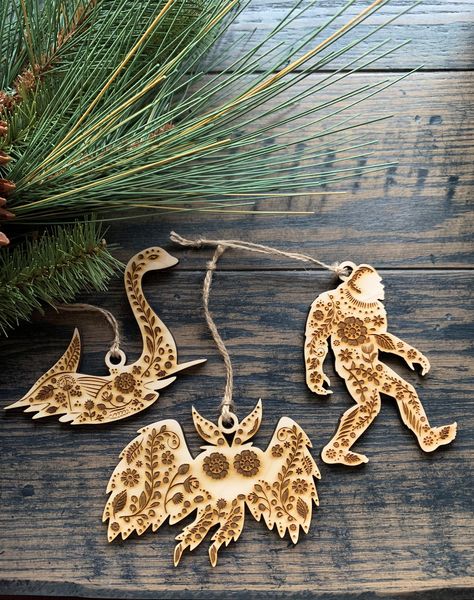 "This unique cryptid ornament set is done in Scandinavian Folk Art style with a beautiful pattern engraved on them that matches our Jackalope and Woodland Animal set. They are very lightweight- made of 1/4\" thick sealed birch or maple ply and measures about 4 1/2\" x 3\". You can use them as gift tags, everyday decor, or would make an awesome addition to your Christmas tree! Comes with a natural jute twine for hanging. Choose from Nessie, Mothman, Bigfoot, or save when you buy the whole set of Nordic Christmas Scandinavian Style, Homemade Xmas Gifts, Christmas Scandinavian Style, Scandinavian Holiday Decor, Woodland Christmas Decor, Woodland Christmas Tree, Scandinavian Christmas Decorations, Creepy Christmas, Everyday Decor