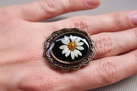 🌿These wildflower ring made from little chamomile flower and eco friendly jewerly epoxy resin. I grow up these flowers in my garden with very big love and carefully dry them. They are Absolutely look like fresh, right? All of them i grew in my garden this summer. 🌿DESCRIPTION * Flower: Chamomile * Metal: Stainless steel, bronze * Pendant Size: 20mm * Length of ring : 25mm 🌿Items will come packaged in a beautiful gift box, ready for gifting. This is lovely gift for any lover of nature. If u wa Dried Chamomile, Plant Terrarium, Big Ring, Natural Jewelry, Botanical Jewelry, Black Resin, Big Rings, Resin Ring, Bronze Pendant