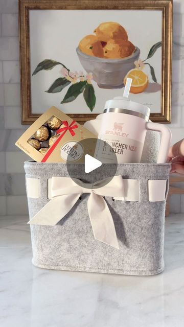 Maria Simonelli on Instagram: "Need a simple yet thoughtful last minute gift idea for her? I got you covered. Check out this adorable gift basket in a cute bow-front felt basket. It’s filled with a cozy knit throw, soft socks, a Stanley cup, and topped with delicious chocolates. 🎁✨ Perfect for any occasion! Want to create your own? Just comment ‘Shop’ and I’ll send you all the links. #giftideasforher #giftideas #giftbaskets #giftbasketsforalloccasions #lastminutegifts" Stanley Christmas Gift Basket, Stanley Gift Ideas Filled, Stanley Cup Gift Basket Ideas, Stanley Gift Basket, Stanley Gift Ideas, Winter Blanket Gift Basket, Stanley Cup Gift Ideas Filled, Open Basket Gift With Blanket Under, Cosy Gift Basket