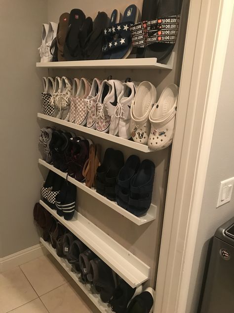 Needed a Shoe solution for our garage entrance. This shoe rack keeps the shoes off the floor and only sticks out 4” from the wall. Keeping everything clear and organized. Made with IKEA Picture ledge shelves, and a paint wash on the plywood we attached them to. Shoe Organization Wall, Ceiling Shoe Rack, Shoe Rack Wall Mounted, Pegboard Shoe Rack, Shoe Storage Behind Door, Shoe Storage On Stairs, Shoe Wall Shelves, Shallow Shoe Storage, Wall Shoe Shelf