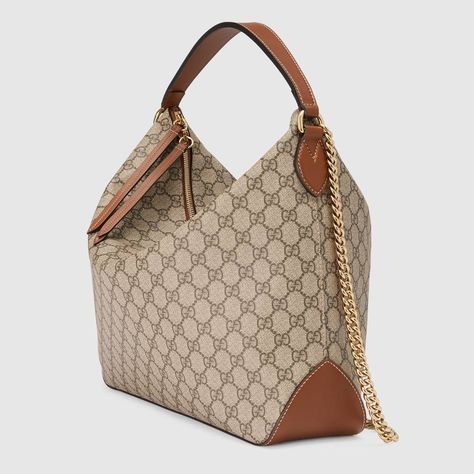 Shop the GG Supreme large hobo by Gucci. A large hobo with an attached chain shoulder strap and a leather top handle. The handles have been hand-stitched with a padded base. The GG Supreme canvas is crafted from a coated microfiber fabric with the GG motif. Large Hobo Bag, Gucci Shoulder Bag, Lv Handbags, Prada Handbags, Designer Shoulder Bags, Gucci Handbags, Small Shoulder Bag, Gucci Bags, Coco Chanel