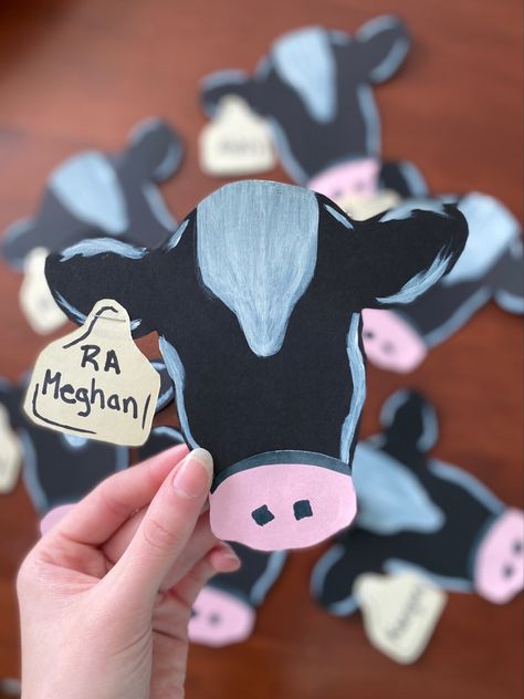 Cute cow head shaped door tags. Black head sill outs cutout facing forward. White spots painted on the head and a pink nose cut out. An ear tag stapled on with the name of the resident. Croc Door Decs, License Plate Door Decs, Dorm Door Name Tags Cute Ideas, Ra College Door Dec, Ra Dorm Door Decorations Name Tags, Cow Door Decs, Door Tags College, Door Decs For Ra, College Door Name Tags