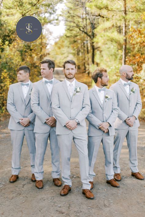 Soft gray suits for this December wedding. The groom stands out with a light gray tie while groomsmen don traditional bowties in light blue matching the bridesmaid dresses. All are wearing matching brown shoes. #graysuits #groomsmeningray #graysuitforgroom #sainteterrewedding #groomstyle #weddingdaysuits #groomsmeninspo #weddingparty Light Gray Groomsmen Suits, Light Blue Groomsmen Suits, Light Gray Groomsmen, Light Grey Suits Wedding, Groomsmen Attire Grey, Light Gray Suit, Blue Groomsmen Suits, Light Gray Wedding, Gray Groomsmen Suits