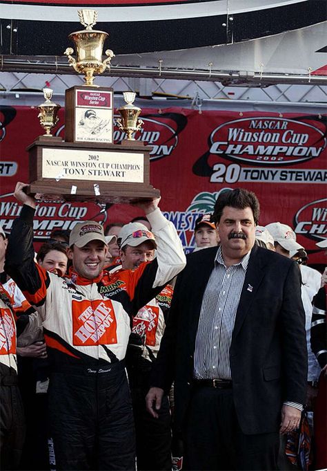 Tony Stewart lifts the NASCAR Winston Cup Championship Trophy as NASCAR President Mike Helton looks on after Stewart won his first championship at the Ford 400 at Homestead-Miami Speedway on Nov. 17, 2002. Nascar Champions, Tony Stewart Racing, One Championship, News Highlights, Tony Stewart, Daytona 500, Nascar Cup Series, Nascar Cup, Memory Scrapbook