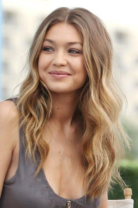 Dirty Blonde Hair Color | ​​​​​​​This low-maintenance color is as effortless as it is timeless. We love how Gigi’s loose waves play up the natural tones of her color. #blonde #hair #color #ideas #trends #southernliving Popelavá Blond, Jahodová Blond, Tmavý Blond, Gigi Hadid Hair, Makeup Contouring, Blonde Hair Colors, Honey Blonde Hair Color, Dark Blonde Hair Color, Strawberry Blonde Hair Color