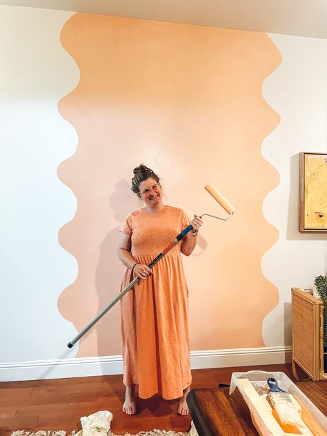 Young lady wearing a peach colored mid calf dress is holding a paint roller with an extender. She is standing in front of a peach colored squiggle painted on a white wall to create an accent and feature wall in her apartment Wall Painting Ideas Creative Living Room, Wall Painting Designs, Wall Painting Ideas Creative, Accent Wall Design, Long Hall, Wall Murals Diy, Interior Murals, Room Unique, Diy Wall Painting