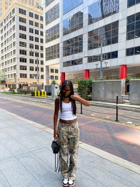 Oversized Camo Pants Outfit, 90s Camo Pants Outfit, Camuflage Outfit Pants, Camo And Black Outfits, Green Telfar Bag Outfit, Green Camo Pants Outfits, Camp Cargo Pants Outfit, Real Tree Camo Pants Outfit, Camo Pants Outfit Black Women