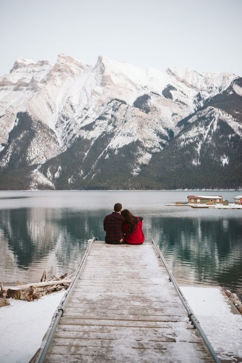 Beautiful young couple sitting on the edge of a snow covered dock in Lake Minnewanka in early winter in Banff National Park. Lake Minnewanka is an incredible place for engagement sessions, weddings and elopements as it has so many places to explore and visit while being very accessible to get to. Bariloche, Lake Minnewanka Engagement, Canada Couple Photos, Banff Winter Wedding, Winter Lake Engagement Photos, Winter Lake Photoshoot, Banff Couple Photos, Lake Minnewanka Banff, Banff Engagement Photos