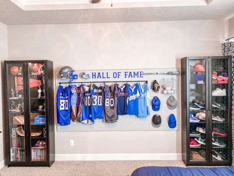 Jersey Bedroom Ideas, Display Jerseys Ideas, Sports Themed Bathroom, Sports Theme Game Room, Sports Jersey Display Ideas, Sports Metal Display Ideas, Sporty Apartment Decor, Sports Display Wall, Teenage Sports Bedroom