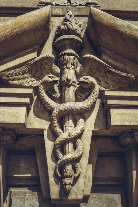 Carved caduceus symbol. Carved bas-relief depicting two serpents twined around the winged caduceus staff as a symbol of commerce, on the frontispiece of the stock images Greek Relief, Hermes Mythology, Hermes Statue, Mud Flood, Greece Mythology, Caduceus Symbol, Bangunan Minecraft, Greek Tattoos, Greek Gods And Goddesses