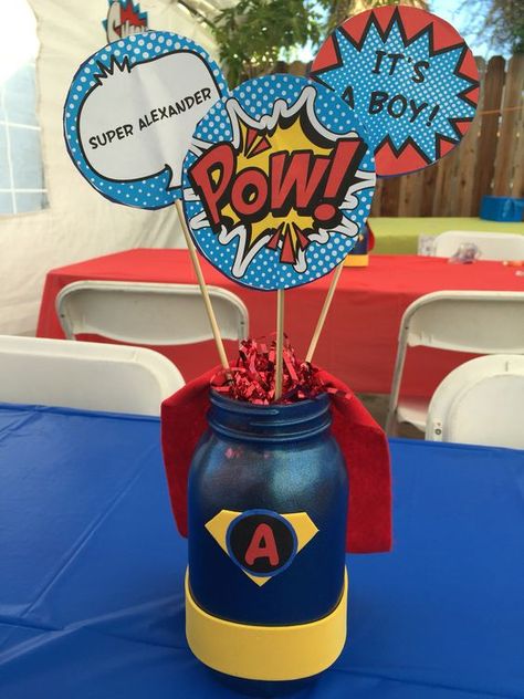 a super hero themed centerpiece with comics details Superman Baby Shower, Marvel Baby Shower, Superhero Centerpiece, Baby Dinosaur Party, Batman Baby Shower, Festa Power Rangers, Dinosaur Baby Shower Theme, Batman Baby, Baby Shower Ideas For Boys