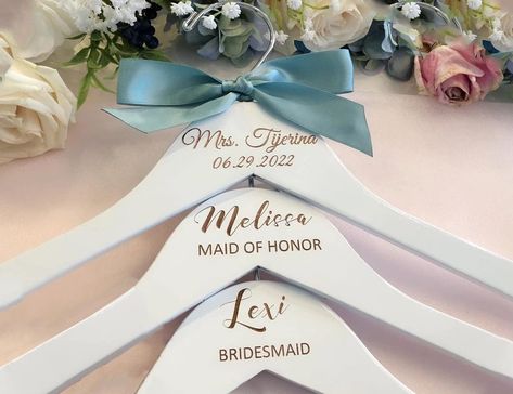 PRICES MAY VARY. Made from the finest quality white lacquered beech wood and finished off with a chrome hook, this dress hanger looks classic and stylish. Make your wedding day even more special with our personalized hangers engraved especially for you. Not only such hangers will look amazing in your wedding photos, but will also make a wonderful keepsake for you and your bridesmaids. Such an amazing idea to make your big day memorable for your friends for years to come Each hanger is individual Bride Hanger Personalized, Personalized Bridesmaid Hangers, Bridesmaid Hanger, Custom Wedding Hangers, Engraved Hangers, Bridal Hangers Personalized, Hanger Wedding, Bridesmaid Hangers, Bridal Shower Gifts For Bride