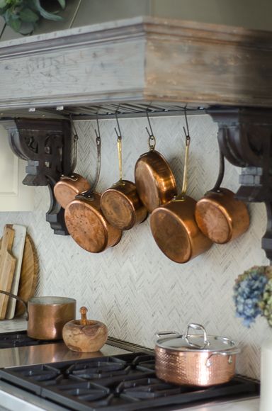 Hanging copper pots behind range. Hanging Copper Pots, Copper Pots Display, Copper Kitchen Accents, Copper Pots And Pans, Sanctuary Home Decor, Copper Kitchen Accessories, Sanctuary Home, Kitchen Center Island, Copper Kitchen Decor